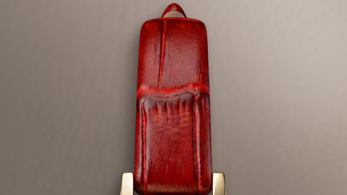Close-up of the Cavatina® Mini’s glossy red croc-embossed leather strap.