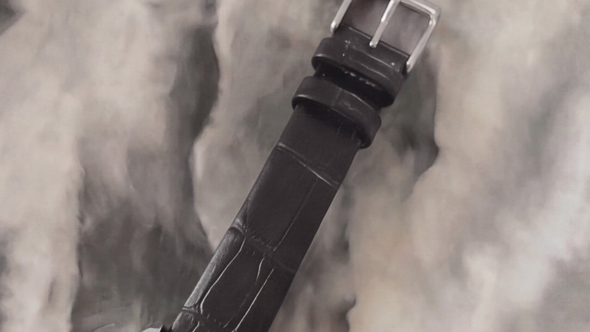 Close-up of the Addison watch’s black croc-embossed leather strap and silver-tone buckle.