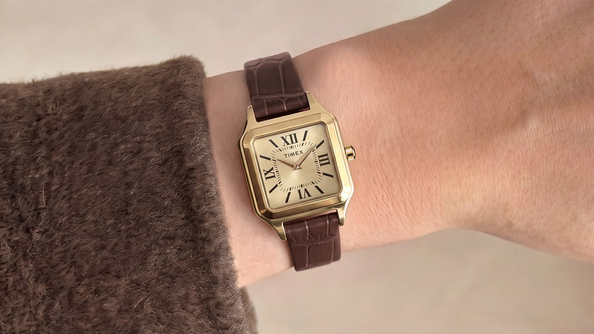 Timex Addison watch with a gold-tone case and brown croc-embossed leather strap worn on the wrist.