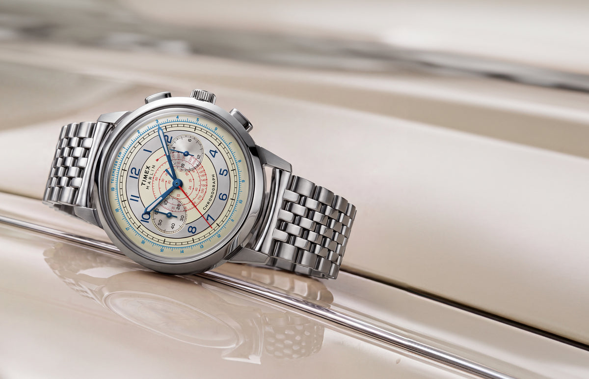 Marlin® Neo Classic Chronograph with a cream dial, blue hands, red markings, and stainless-steel bracelet resting on a cream-colored car.