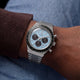 Ice-blue Q Timex Chronograph with black subdials and a stainless-steel bracelet worn on the wrist.
