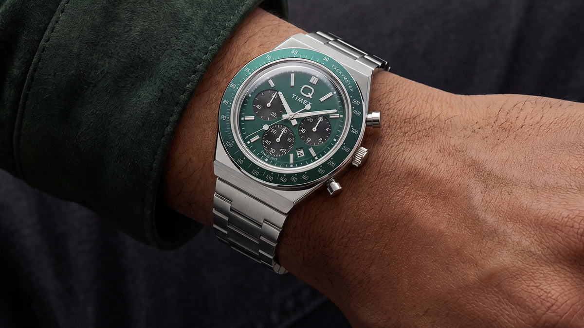 Q Timex Chronograph with a green dial and stainless-steel bracelet worn on the wrist.