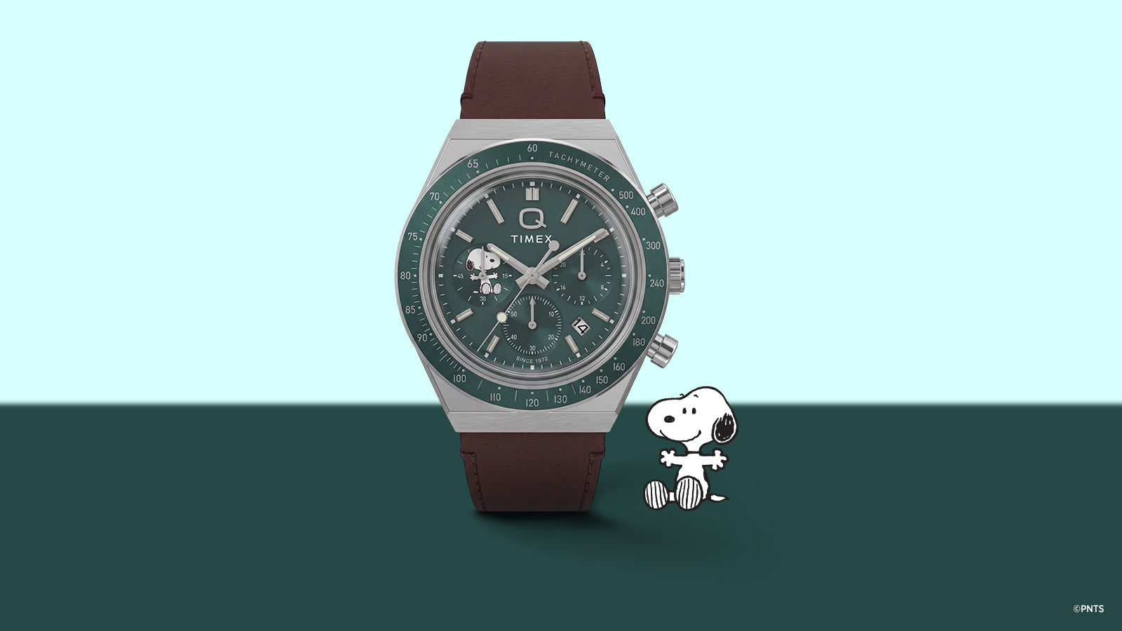 Vista frontal del cronógrafo Peanuts® x Q Timex, con esfera verde, subesfera de Snoopy, bisel taquimétrico y correa de piel marrón.
