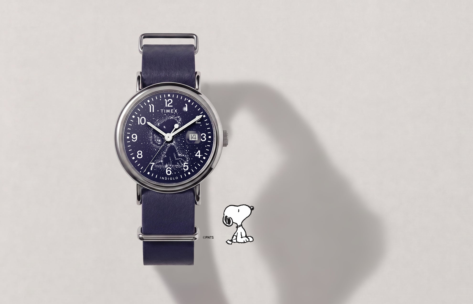 Reloj Peanuts® x Timex Weekender Astronomy con correa azul marino, caja en tono plateado, esfera con la constelación de Snoopy y ventana de fecha.