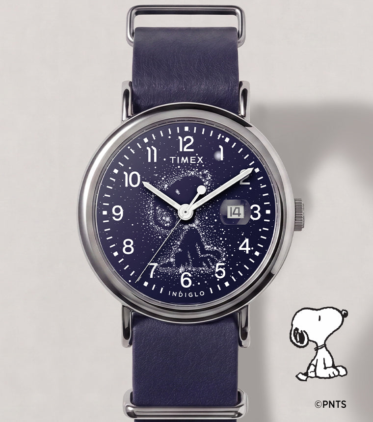 Reloj Peanuts® x Timex Weekender Astronomy con correa azul marino, caja en tono plateado, esfera con la constelación de Snoopy y ventana de fecha.