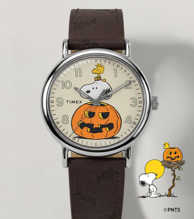 Peanuts® x Timex Weekender® Pumpkin watch with a brown leather strap and a cream dial featuring Snoopy, Woodstock, and a jack-o’-lantern.