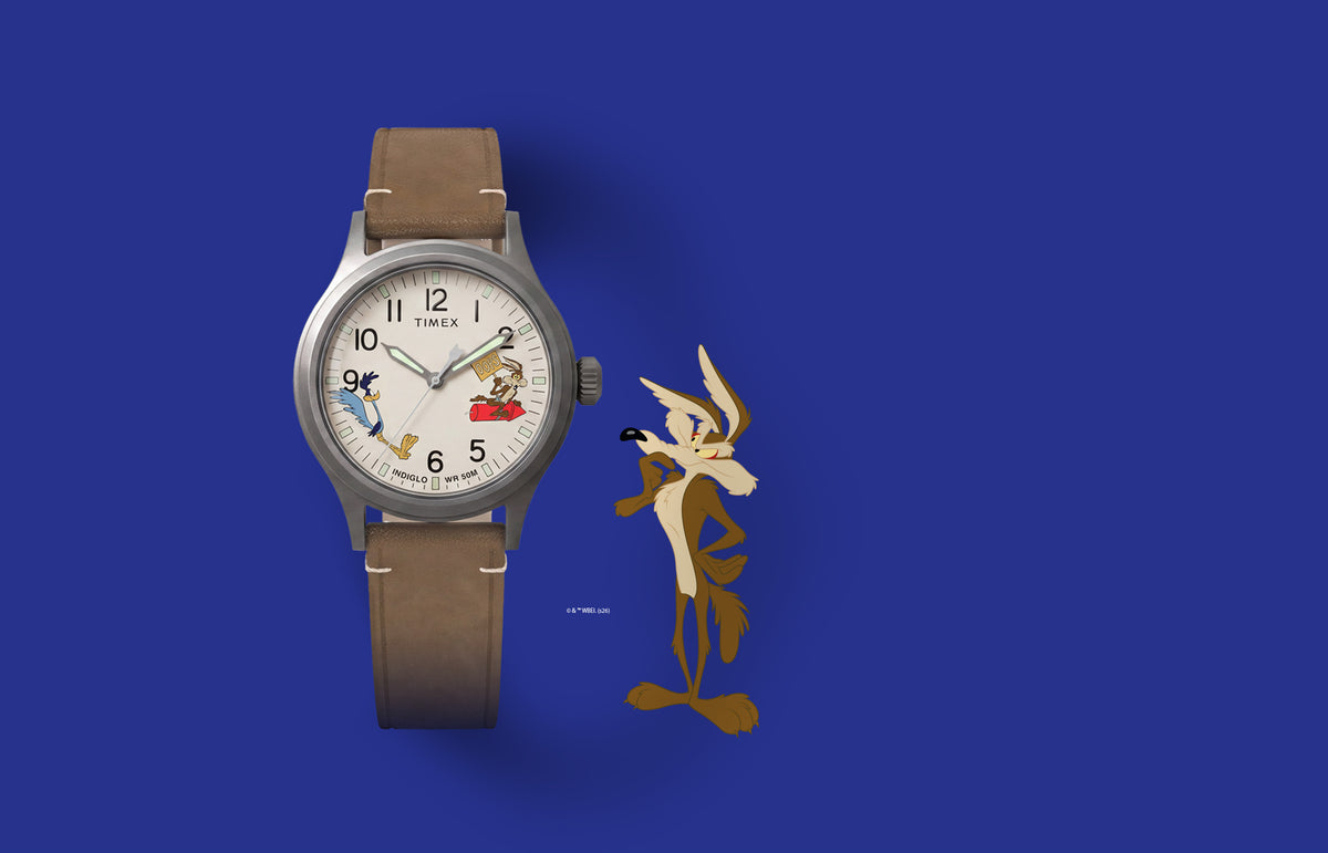 TW2Y99400 Reloj Timex Expedition® Scout de Looney Tunes con el Correcaminos y el Coyote, con una esfera de color crema con motivos de los personajes y una correa de piel marrón con ilustraciones del Coyote.