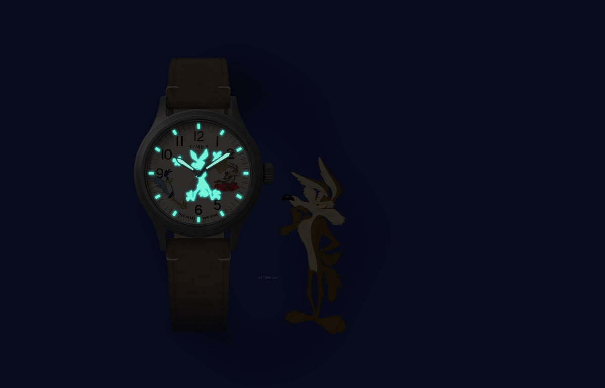 TW2Y99400 Reloj Road Runner & Wile E. Coyote x Timex Expedition® Scout con agujas y índices de color turquesa que brillan en la oscuridad, y una silueta oculta de Wile E. Coyote.