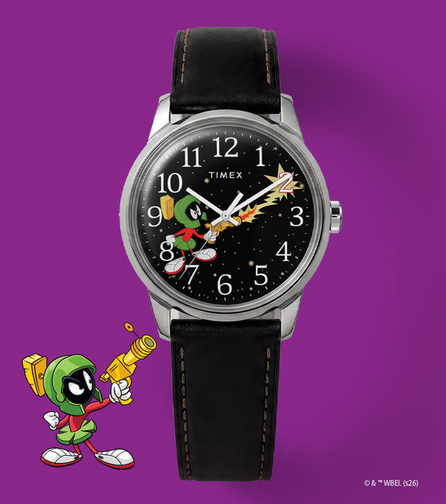 TW2Y99300 Looney Tunes Marvin the Martian x Timex Easy Reader® watch with a black character dial and black leather strap beside Marvin artwork on purple.