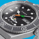 TW2Y99200 Detailed view of the black dial with reclining Bugs Bunny artwork, his signature, a carrot-shaped seconds hand, and a day-date display.