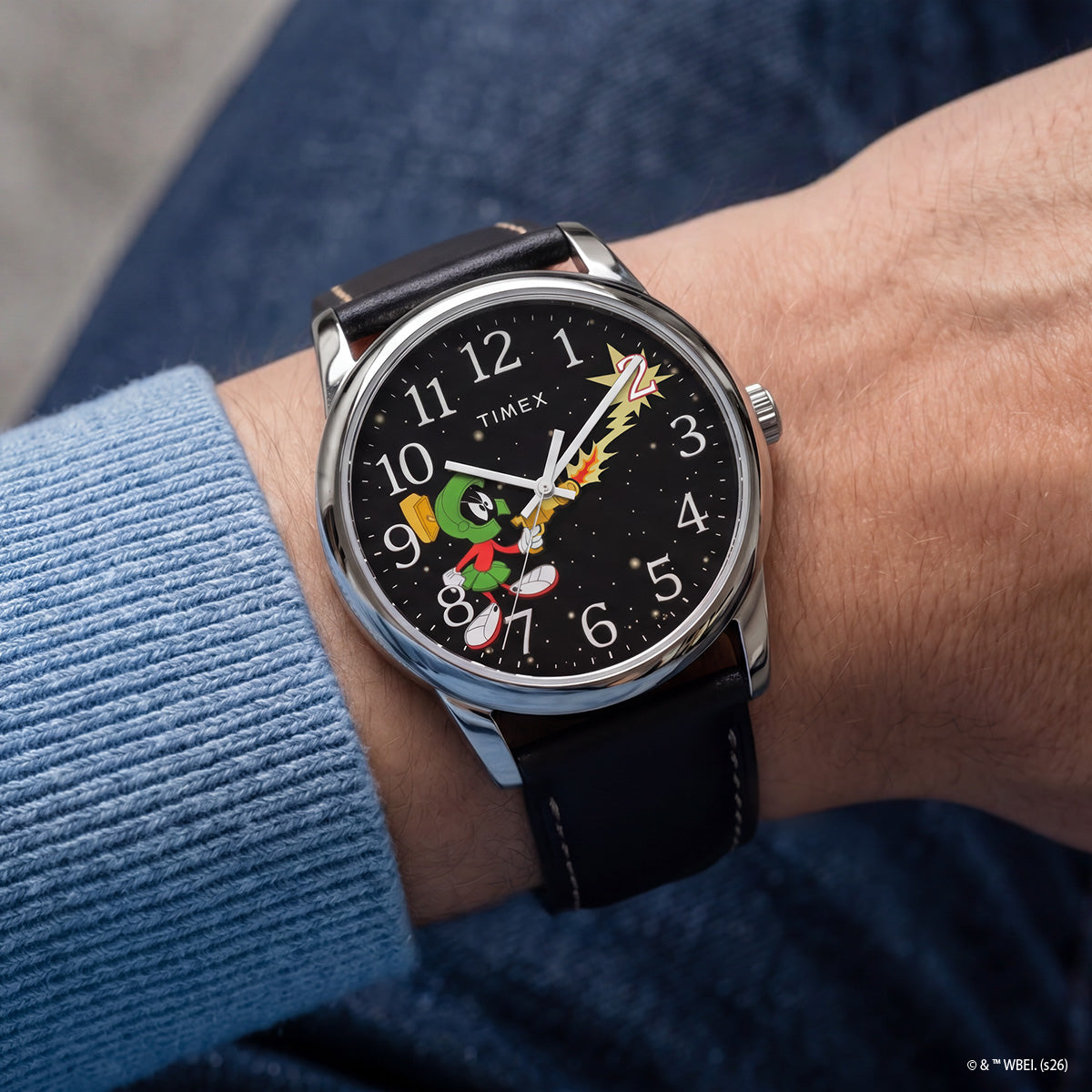 TW2Y99300 Marvin the Martian x Timex Easy Reader® watch worn on a wrist, featuring a black starry dial, silver-tone case, and black leather strap.