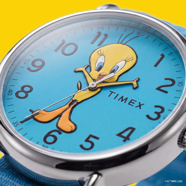 TW2Y99500 Close-up of the blue Tweety Bird x Timex Weekender dial featuring yellow Tweety artwork, black numerals, and silver-tone hands.