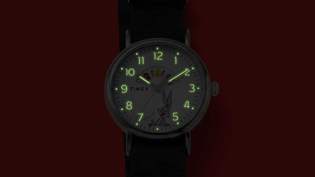 TW2Y99100 Looney Tunes Bugs and Friends x Timex Standard watch with hands, numerals, and hour markers glowing green in the dark.
