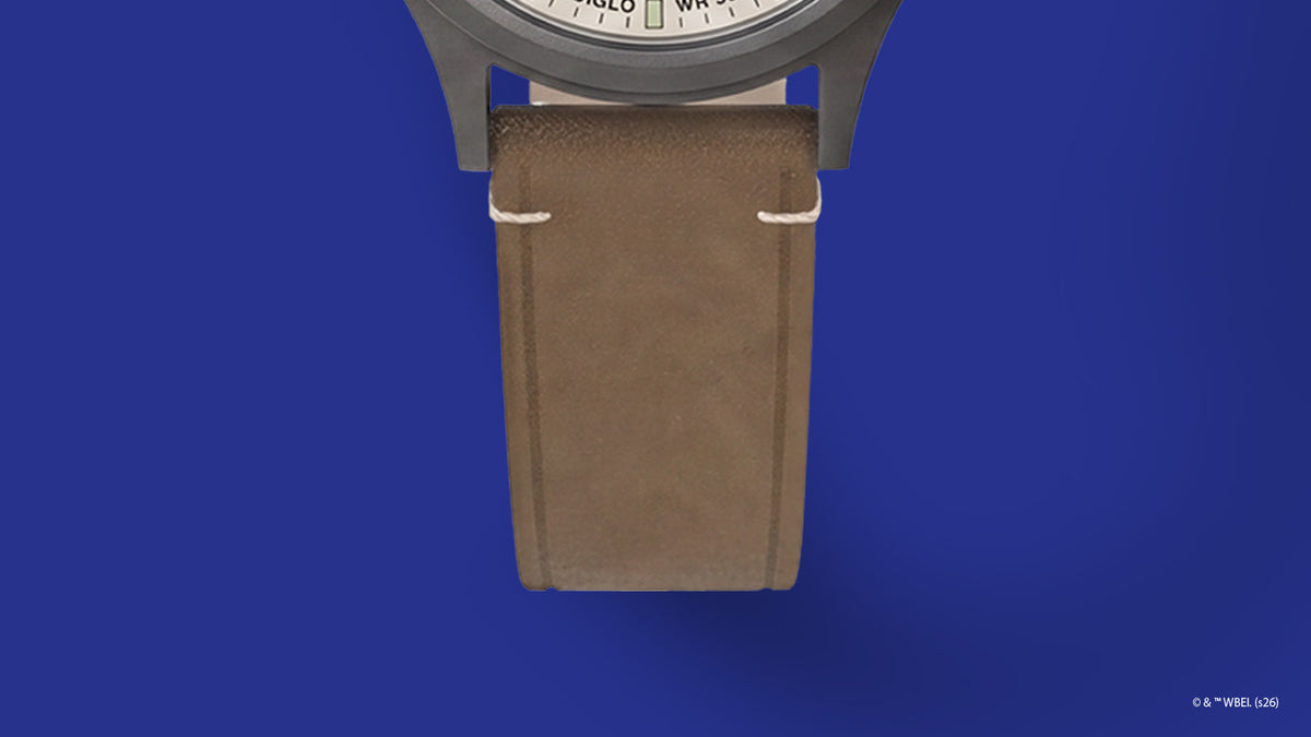 TW2Y99400 Primer plano de la correa de piel marrón con costuras color crema del reloj Road Runner & Wile E. Coyote x Timex Expedition® Scout.