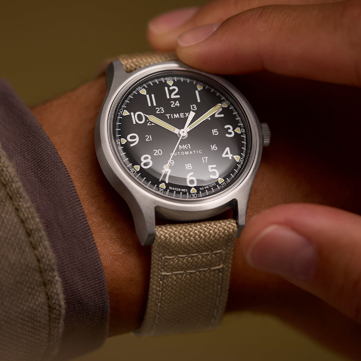 Close-up of a person adjusting the MK1® Automatic watch on their wrist.