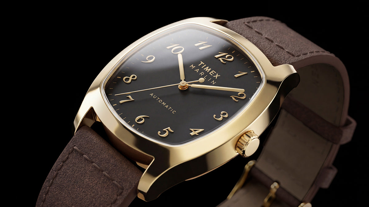 TW2Y84500 Angled close-up of the Marlin® Chatham Automatic watch with a black dial, gold-tone case and brown leather strap.