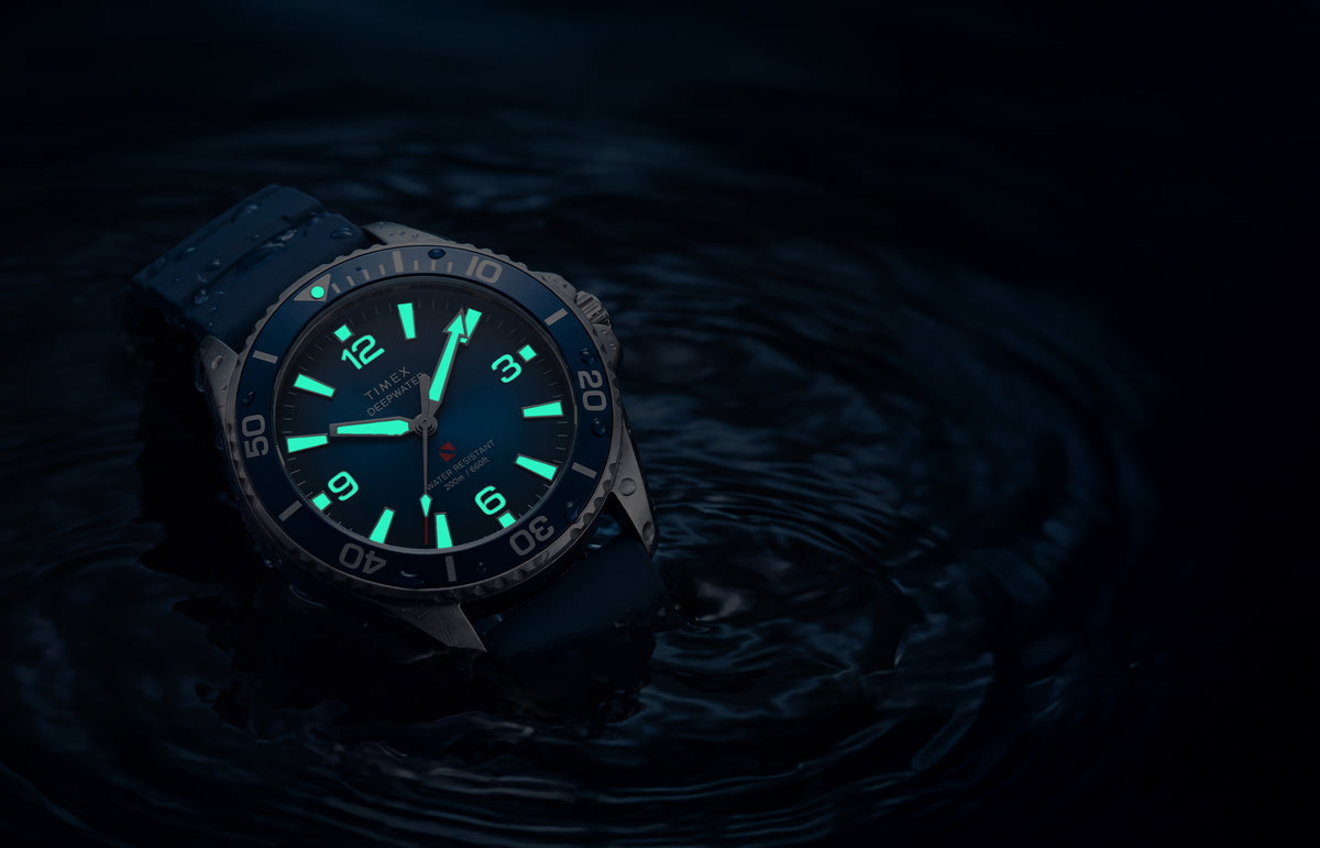 TW3A01900 Deepwater Arctic 200 watch in dark water with luminous hands and hour markers glowing aqua.