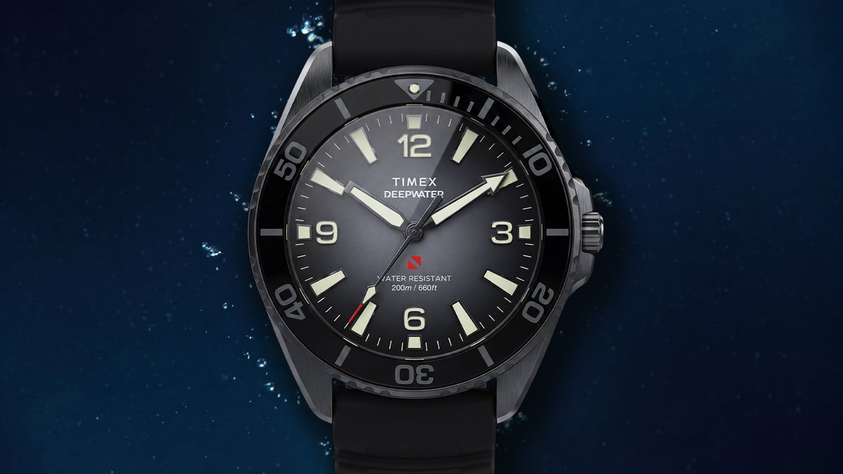 TW3A02000 Front view of the gray Deepwater Arctic 200 watch with a black bezel and strap against an underwater background.
