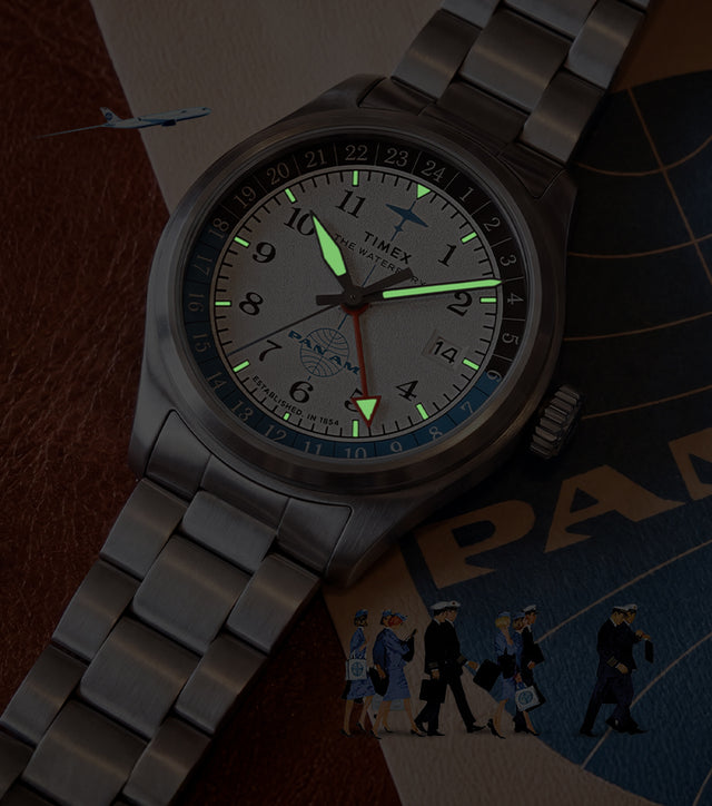 TW2Y94600 Pan Am x Timex Waterbury Automatic GMT watch with luminous hands and hour markers glowing in the dark.