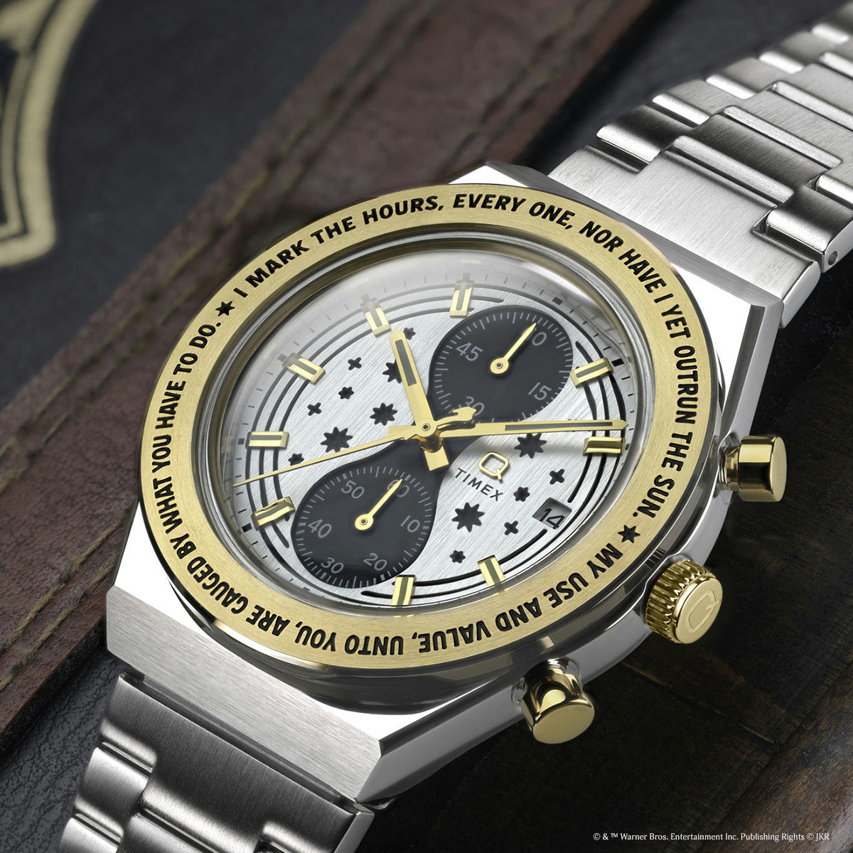 TW2Y75900 Angled close-up of the watch, showing its star-patterned dial, two dark subdials, gold-tone bezel, and metal bracelet.