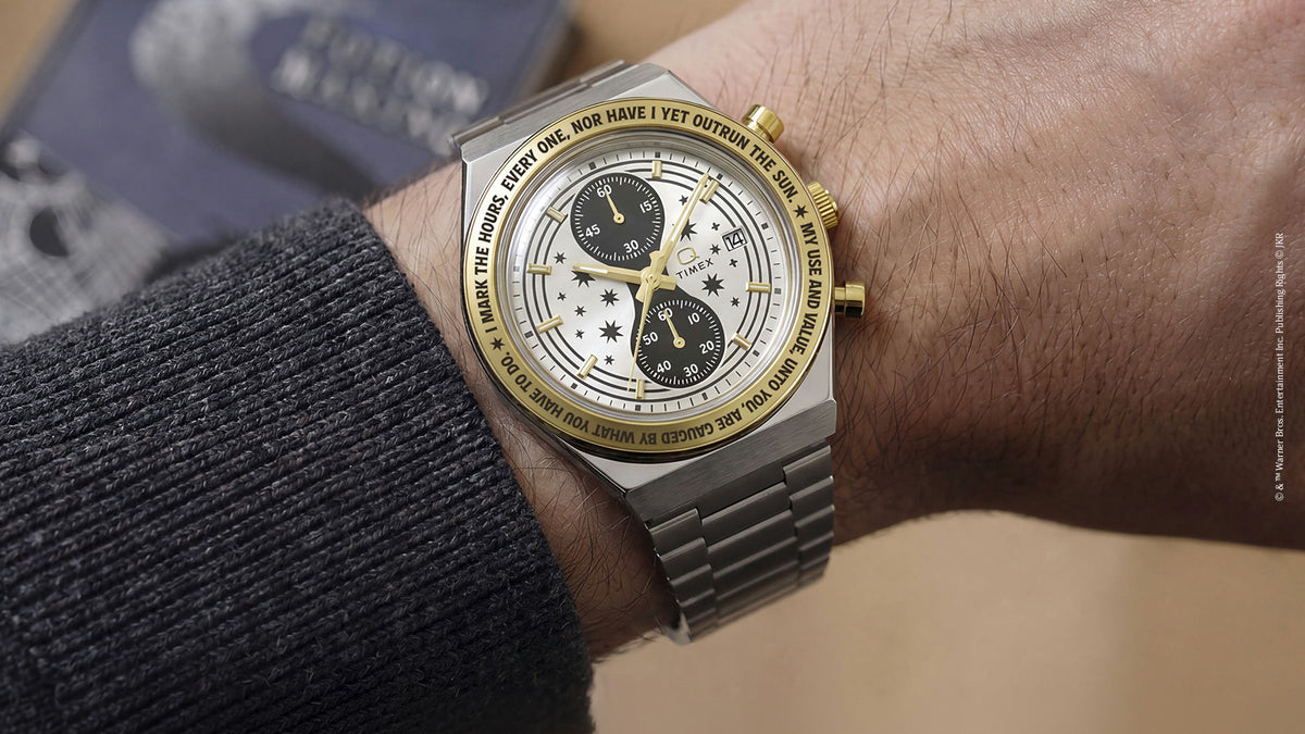 TW2Y75900 Close-up of the watch worn on a wrist, showing its two dark subdials and gold-tone bezel.
