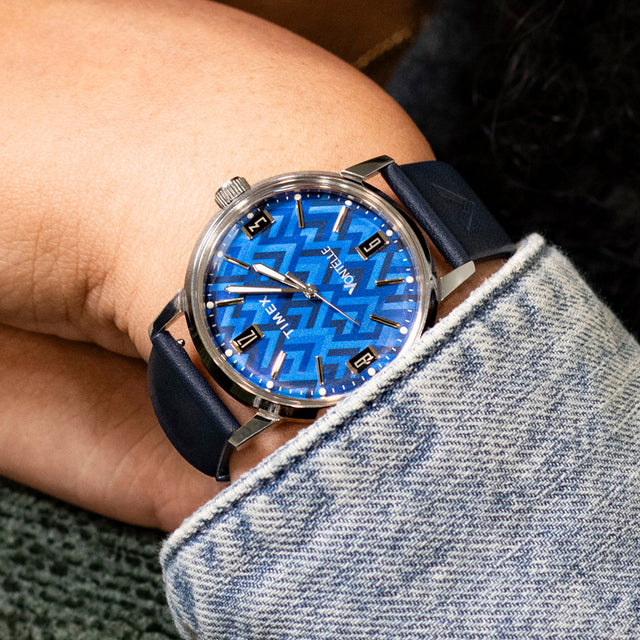 TW2Y73800 Close-up of the blue patterned dial watch worn with a denim jacket.