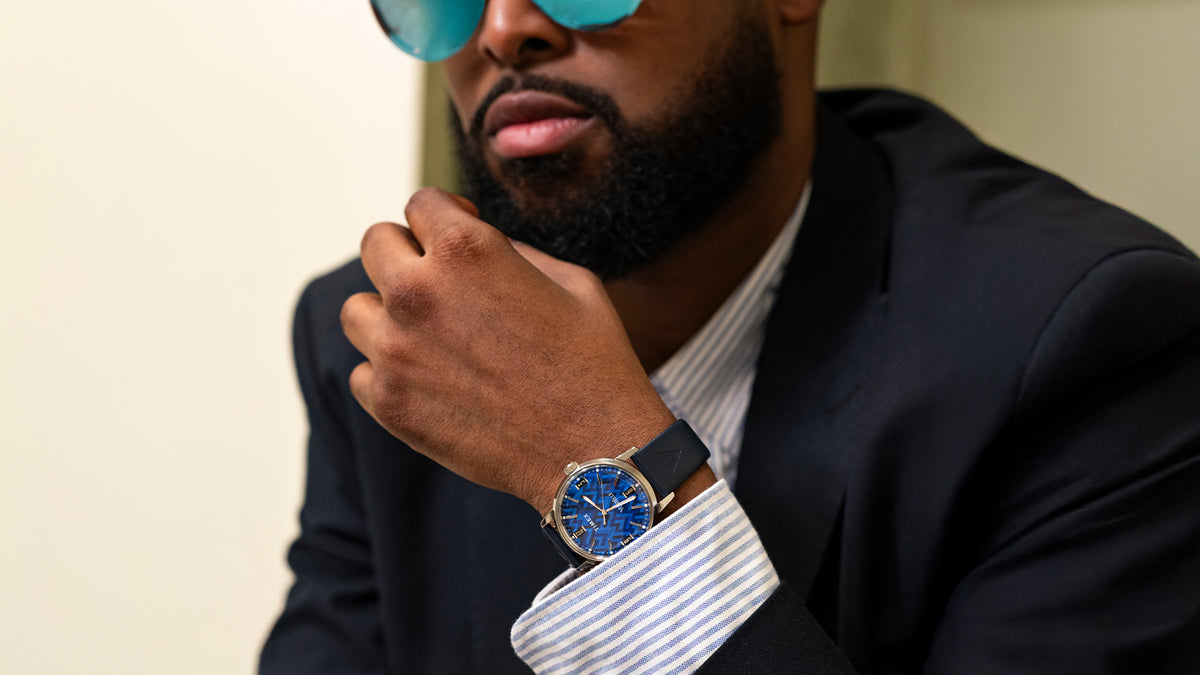 TW2Y73800 Man in a dark suit and blue sunglasses wearing the blue-dial watch on his wrist.