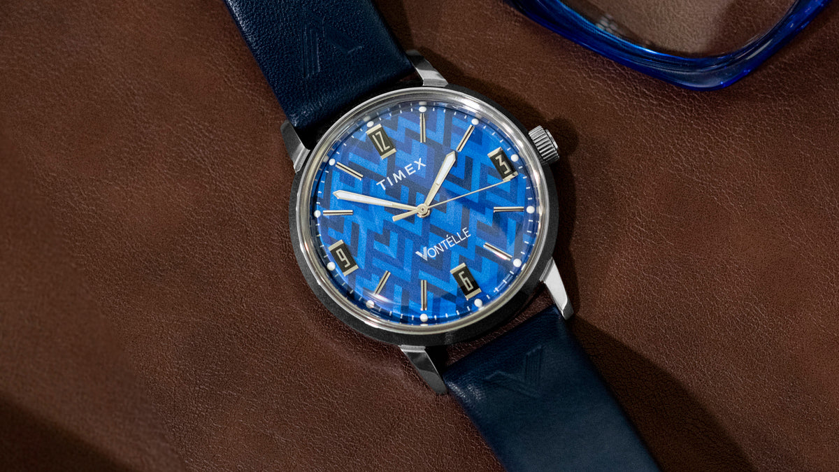 TW2Y73800 Angled view of the blue-dial watch and navy strap beside blue eyeglasses.