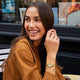 TW2Y90200 Mujer sonriente con una blusa marrón que luce un reloj Timex Cavatina® Crystals junto a una delicada pulsera.