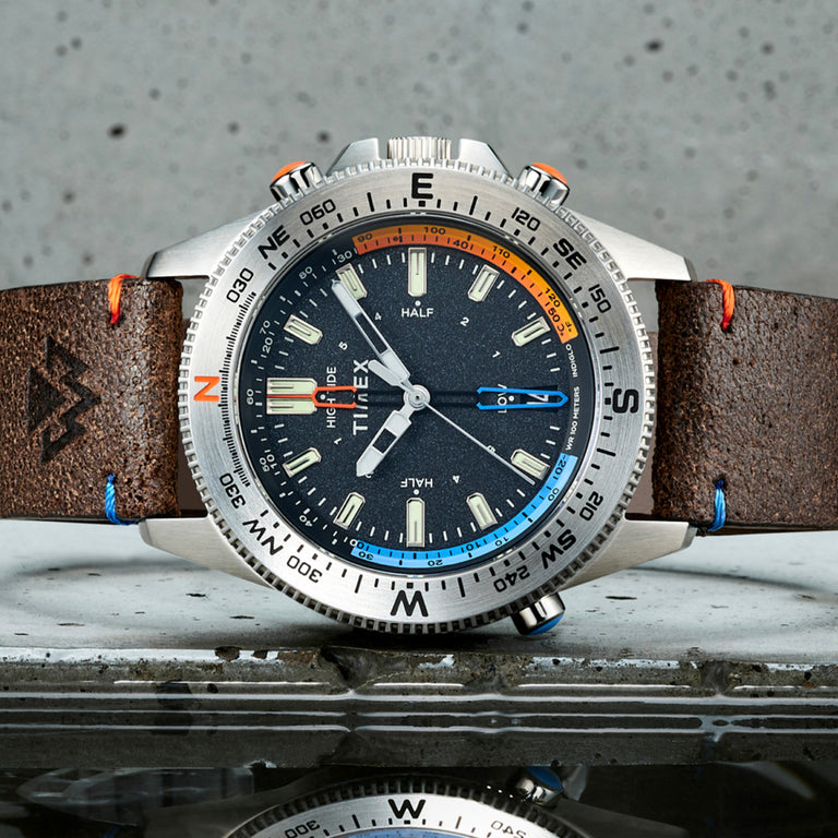 Expedition North Tide-Temp-Compass with a brown leather strap photographed on its side