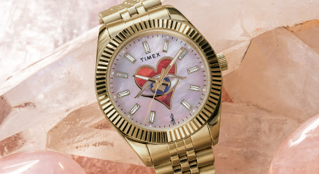 Jacquie Aiche Soulmate Collection featuring a gold-tone watch with pink mother of pearl dial.  The dial also shows a heart with an iconic eye at center.