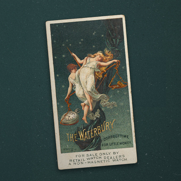 A vintage advertisement card for The Waterbury watch, featuring an illustration of a classical goddess-like figure holding a pocket watch and a scale, with celestial and ornate detailing. Text at the bottom reads, “For sale only by retail watch dealers. A non-magnetic watch.”
