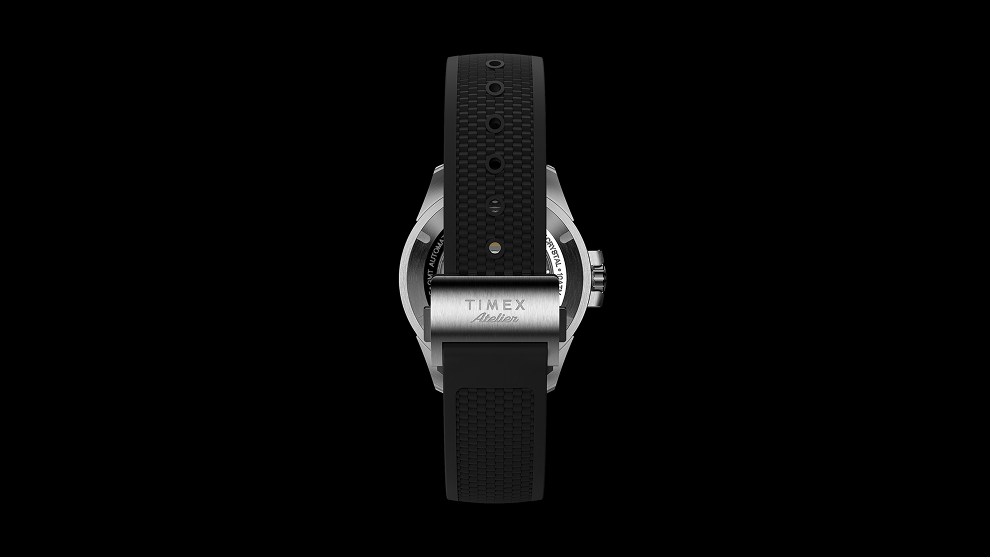 Rear view of the Timex Atelier GMT Automatic with its black textured rubber strap and stainless steel buckle engraved “Timex Atelier.”