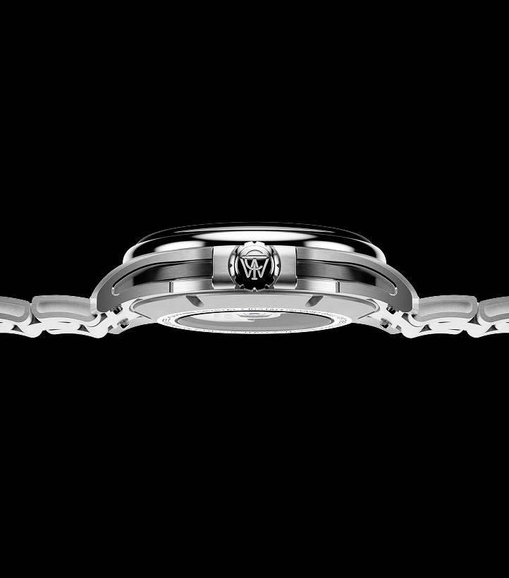 Side profile of the Timex Atelier GMT Automatic watch showing its slim stainless-steel case, engraved crown, and integrated bracelet design.