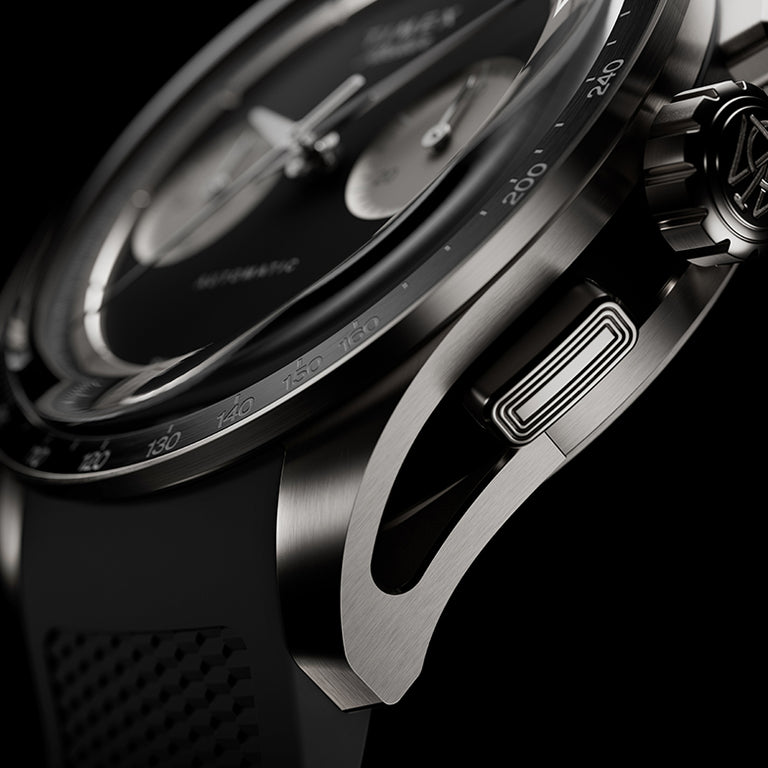 Detailed view of the Timex Atelier Chronograph Automatic M1a Ti highlighting the skeletonized lug design, chronograph pusher, and brushed titanium case finish.