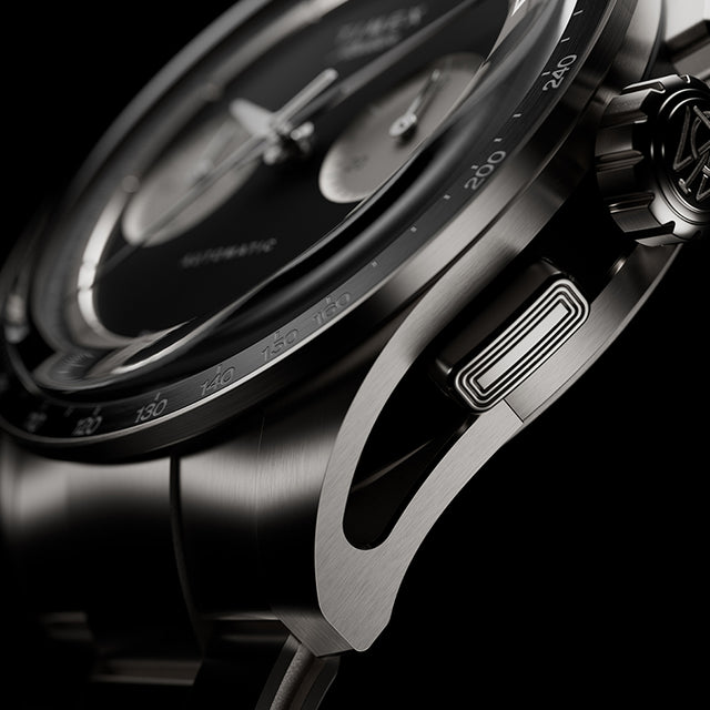 Side detail of Timex Atelier Chronograph Automatic Ti M1a titanium case showing tachymeter bezel, crown, and chronograph pusher
