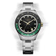 Vista frontal del reloj Timex Atelier GMT Première M1a, con esfera negra, escala GMT verde y brazalete de acero inoxidable.