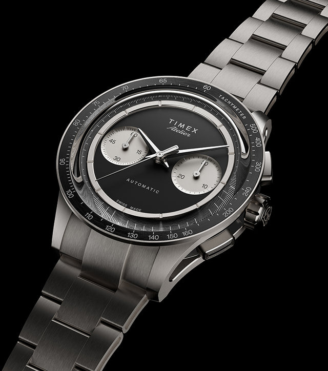 Timex Atelier Chronograph Automatic Ti M1a watch with black dial, titanium case, and integrated bracelet angled on black background