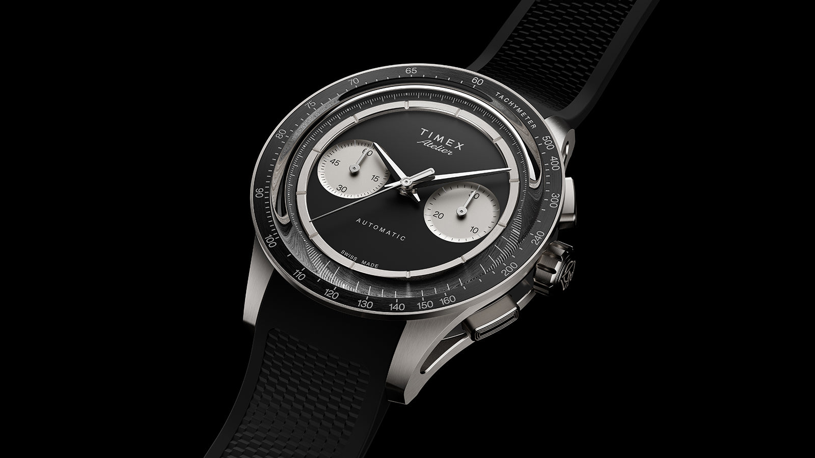 Angled view of Timex Atelier Chronograph Automatic Ti M1a with black rubber strap and titanium case on black background