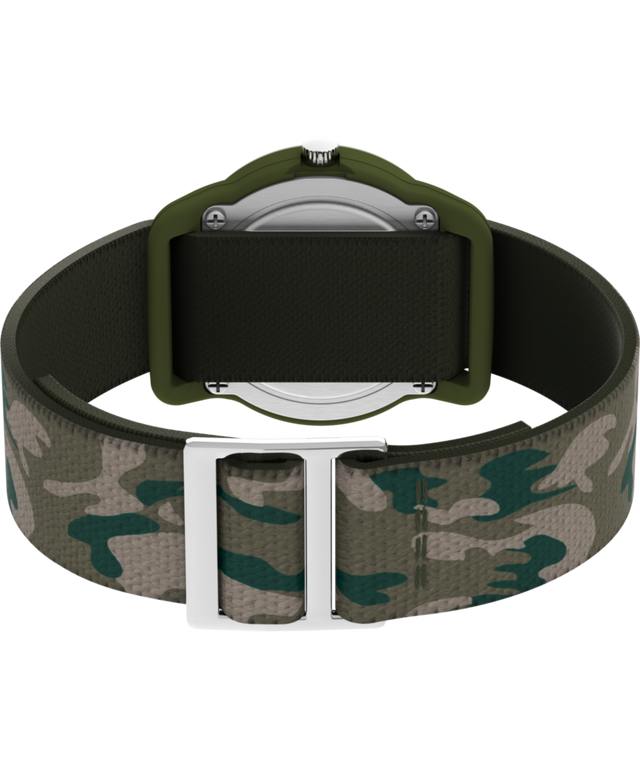 T78141 TIMEX TIME MACHINES® Reloj infantil de 29 mm con correa elástica de tejido de camuflaje verde. Imagen del fondo de la caja con accesorio.