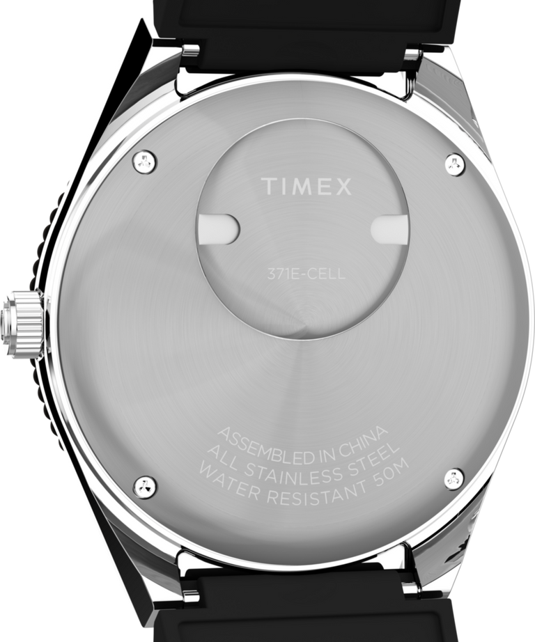 TW2W57500 Q Timex® GMT, reloj de 38 mm con correa de caucho sintético. Imagen del fondo de la caja.
