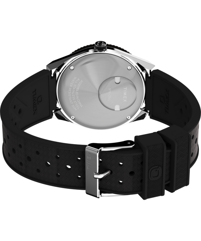 TW2W57500 Q Reloj Timex® GMT de 38 mm con correa de caucho sintético. Imagen del fondo de la caja con accesorio.