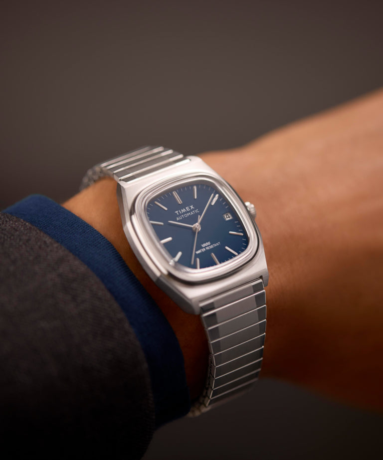 Imagen principal en la muñeca del reloj Timex® Automatic 1983 E Line de 34 mm con correa extensible de acero inoxidable TW2Y07400
