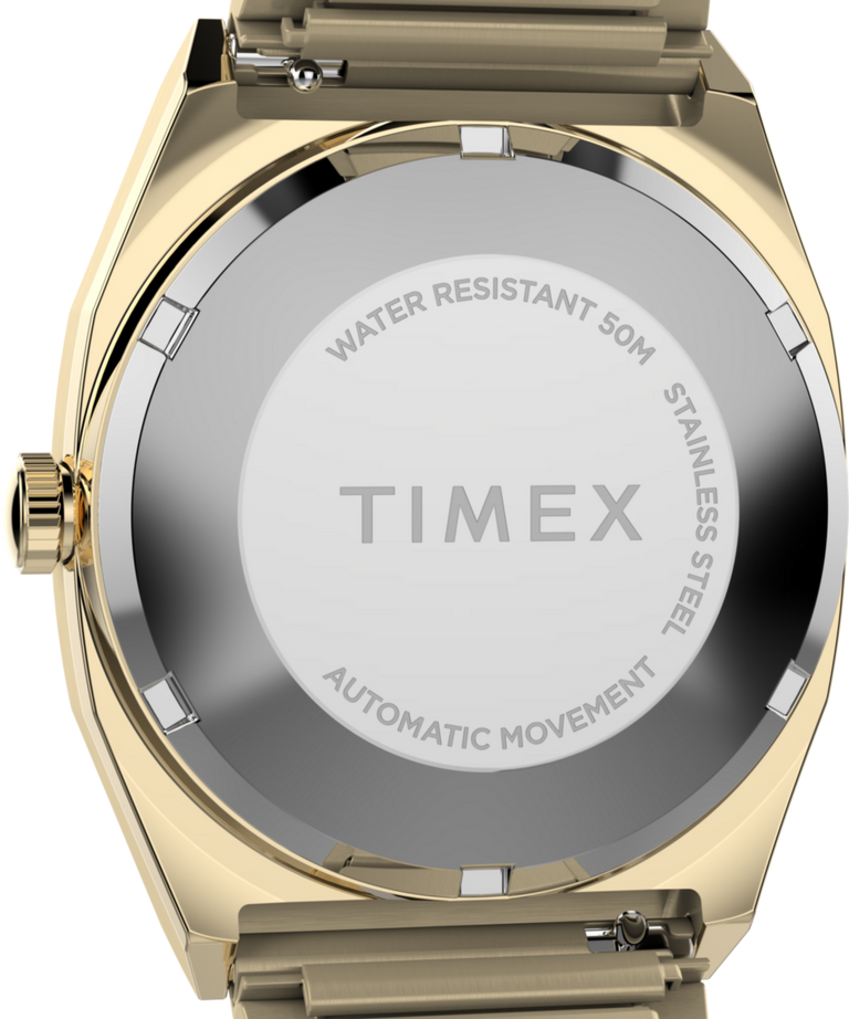 TW2Y67700 Timex® Automático 1983, línea E, 34 mm, reloj con correa extensible de acero inoxidable. Imagen del fondo de la caja.