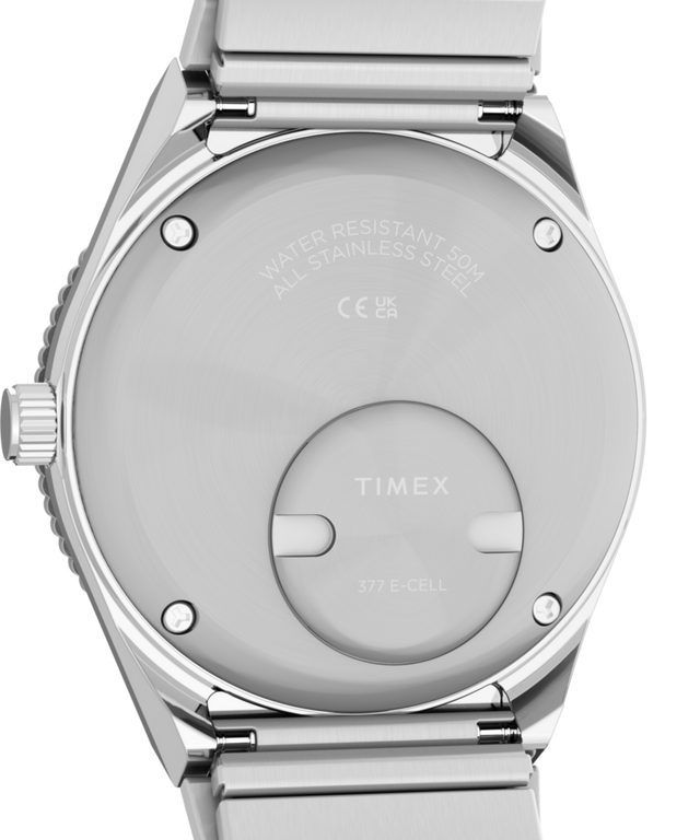 TW2Y77300 Q Reloj Timex® Mini de 30 mm con correa extensible de acero inoxidable  Imagen del fondo de la caja