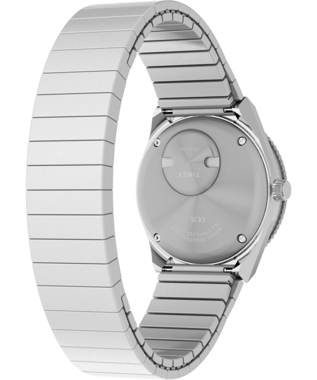 TW2Y77300 Q Reloj Timex® Mini de 30 mm con correa extensible de acero inoxidable. Imagen del fondo de la caja con accesorio.