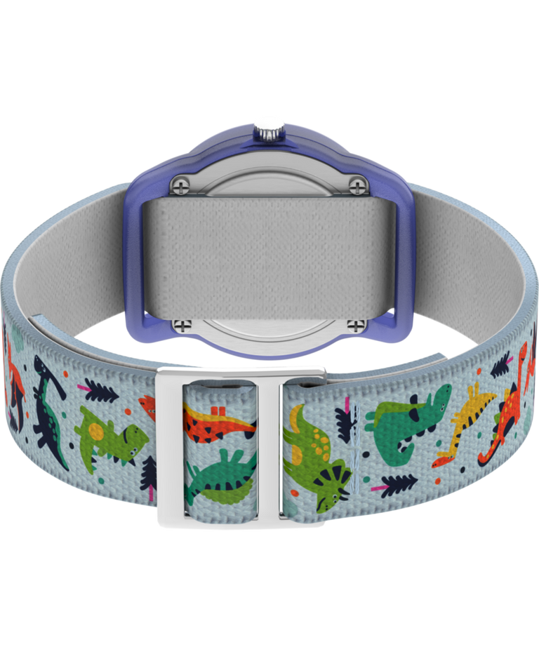 TW7C77300 TIMEX TIME MACHINES® Reloj infantil de 29 mm con correa elástica de tela y motivos de dinosaurios. Imagen del fondo de la caja con accesorio.