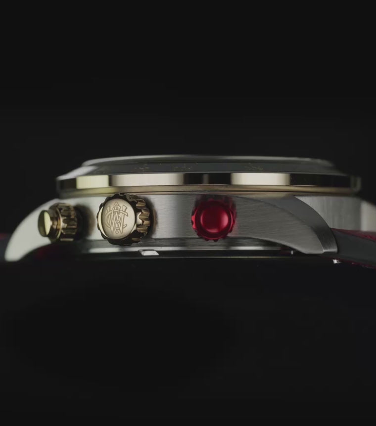 Timex Waterbury Heritage Chronograph with a black dial, gold-tone accents, and red leather strap rotates against a dark background, revealing its chronograph details and glowing green INDIGLO® display.