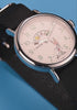 TW2Y99100 Rotating views of the Looney Tunes Bugs and Friends x Timex Standard watch, highlighting its character display, silver-tone case, and black strap against blue and red backgrounds.