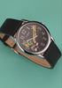 TW2Y99300 Rotating views of the Marvin the Martian x Timex Easy Reader® watch, highlighting its starry character dial, silver-tone case, and black leather strap against green and red backgrounds.